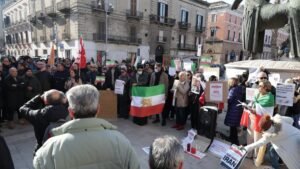 Bari, flash mob per l'Iran in centro: il sindaco Leccese espone la bandiera dalla finestra del Comune con un gesto simbolico ma sentito.